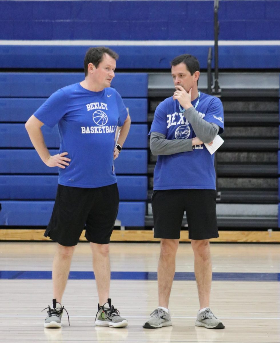 Varsity girls basketball head coach Joshua Price and varsity assistant coach Michael Price talk strategy at practice.