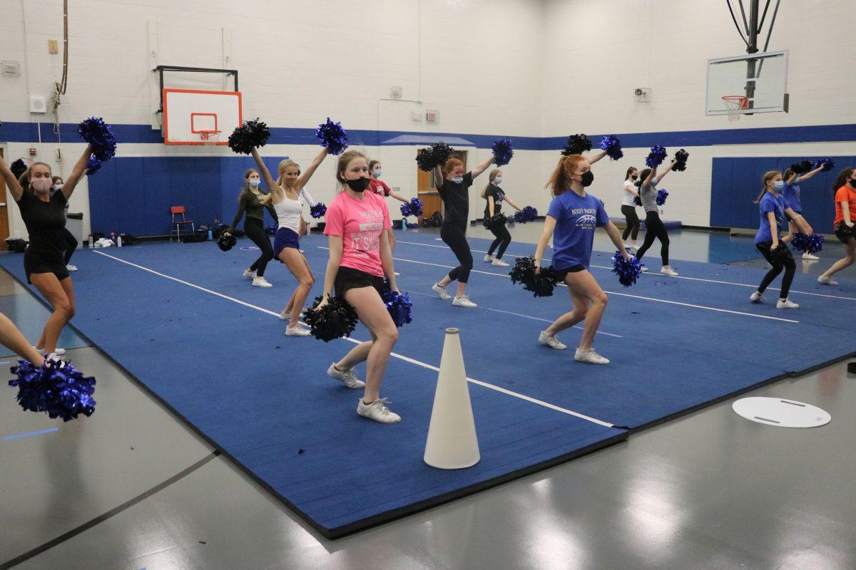 The cheer team perfects their routine positions that they will perform for upcoming competitions. (Photo by Sydney Hoffman)