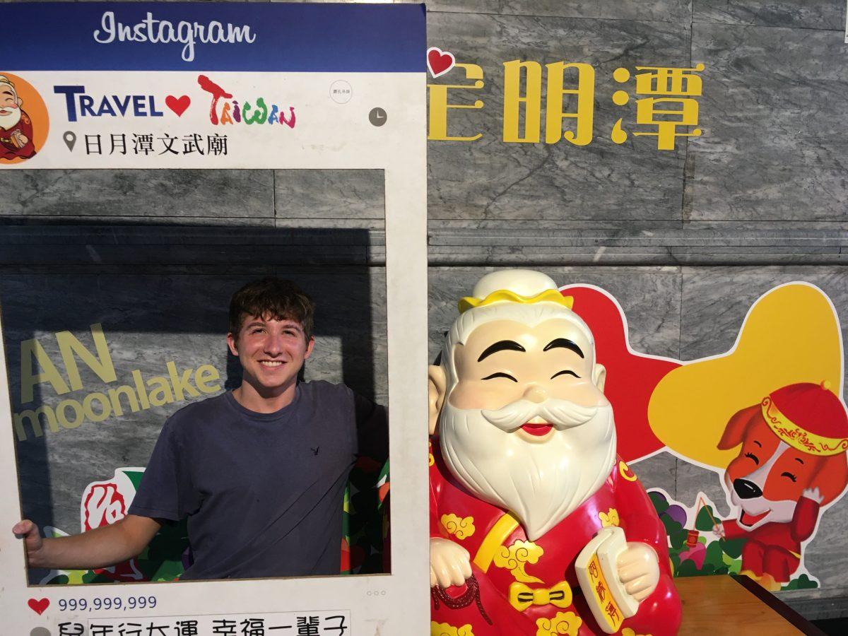 Senior Gavin Levine poses with Yue Lao, the Chinese matchmaker deity, at a temple by Sun Moon Lake in Taiwan.
