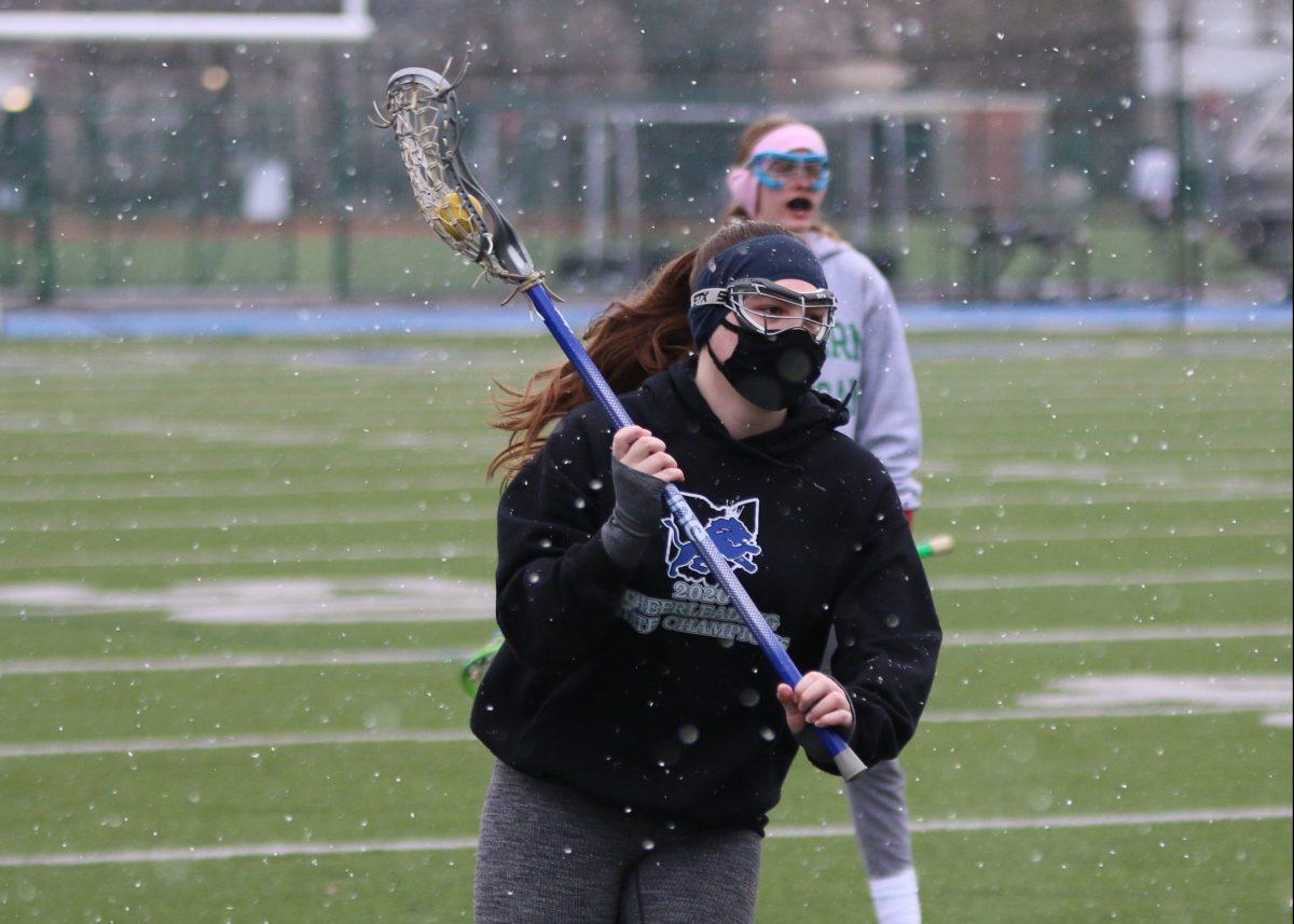 Junior Kara Kilbourne cradles the ball down the field in a lacrosse preseason practice. (Photo by Katie Jude)
