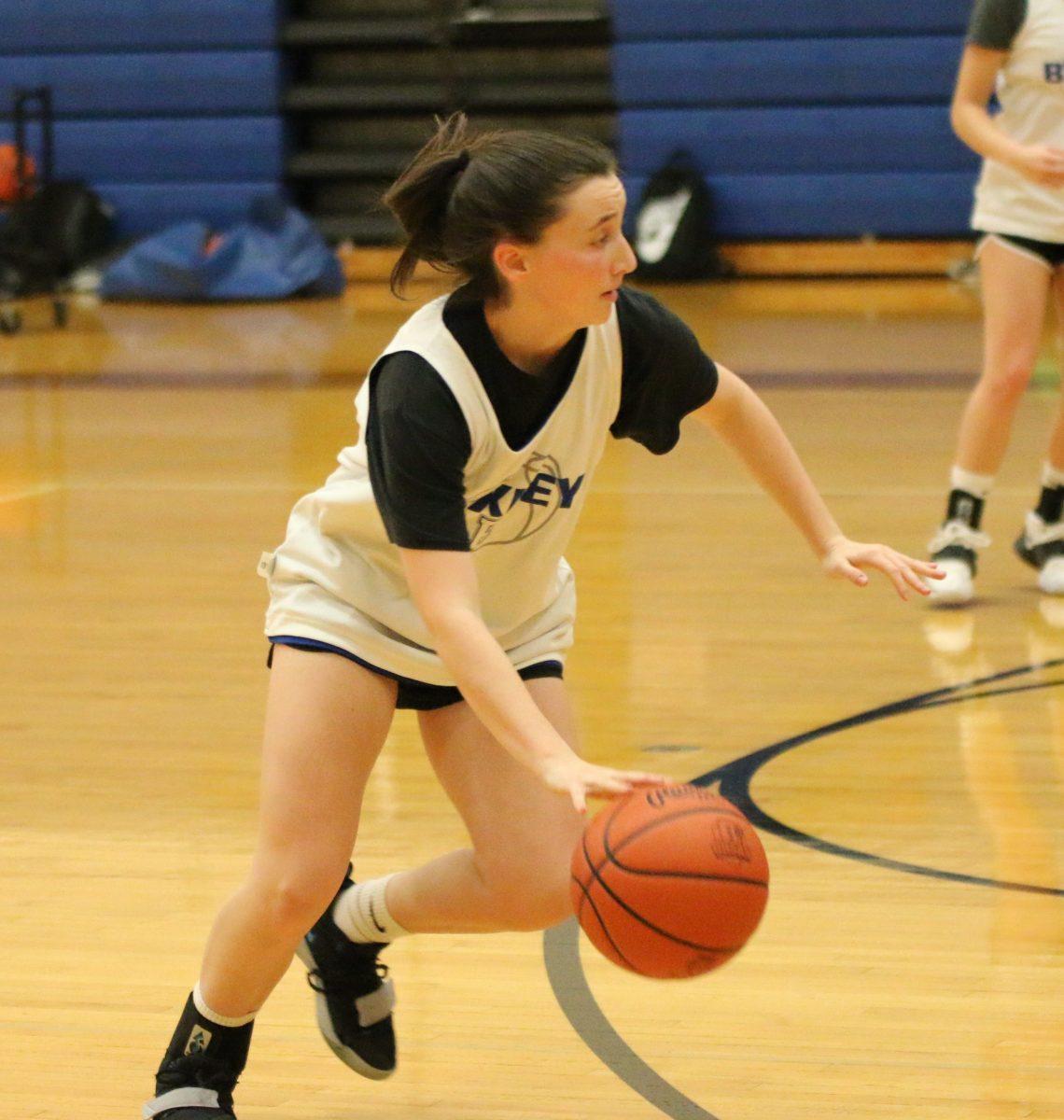 Senior Maddy Young works on her ball handling during a drill at basketball practice. (Photo by Emma Magee)