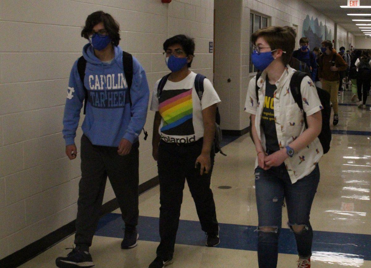 Zach Trabitz (left), Ru Sivaraman (center), and Allison Taylor (right) walk together through the hallways on the first day of all in-person school while all wearing the district distributed masks. (Photo by Margaret Zirwas)