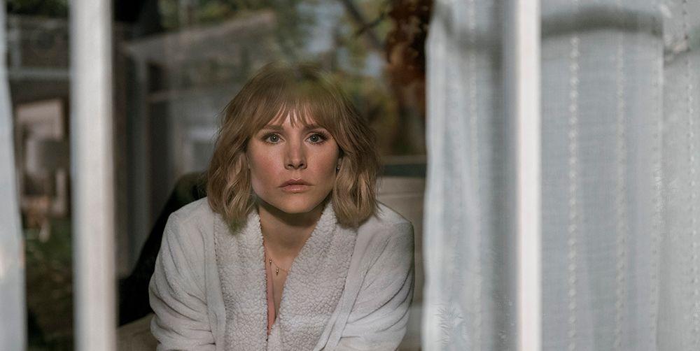 Anna (Kristen Bell) stares out her window, watching her new neighbors move in. (Fair use Syfy)