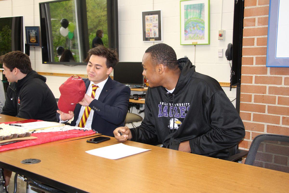 Seniors Louis Berger and Chris Mitchell prepare to sign their Division III celebratory signing form Wednesday, May 4.
(Photo by Gabrielle Cabanes)