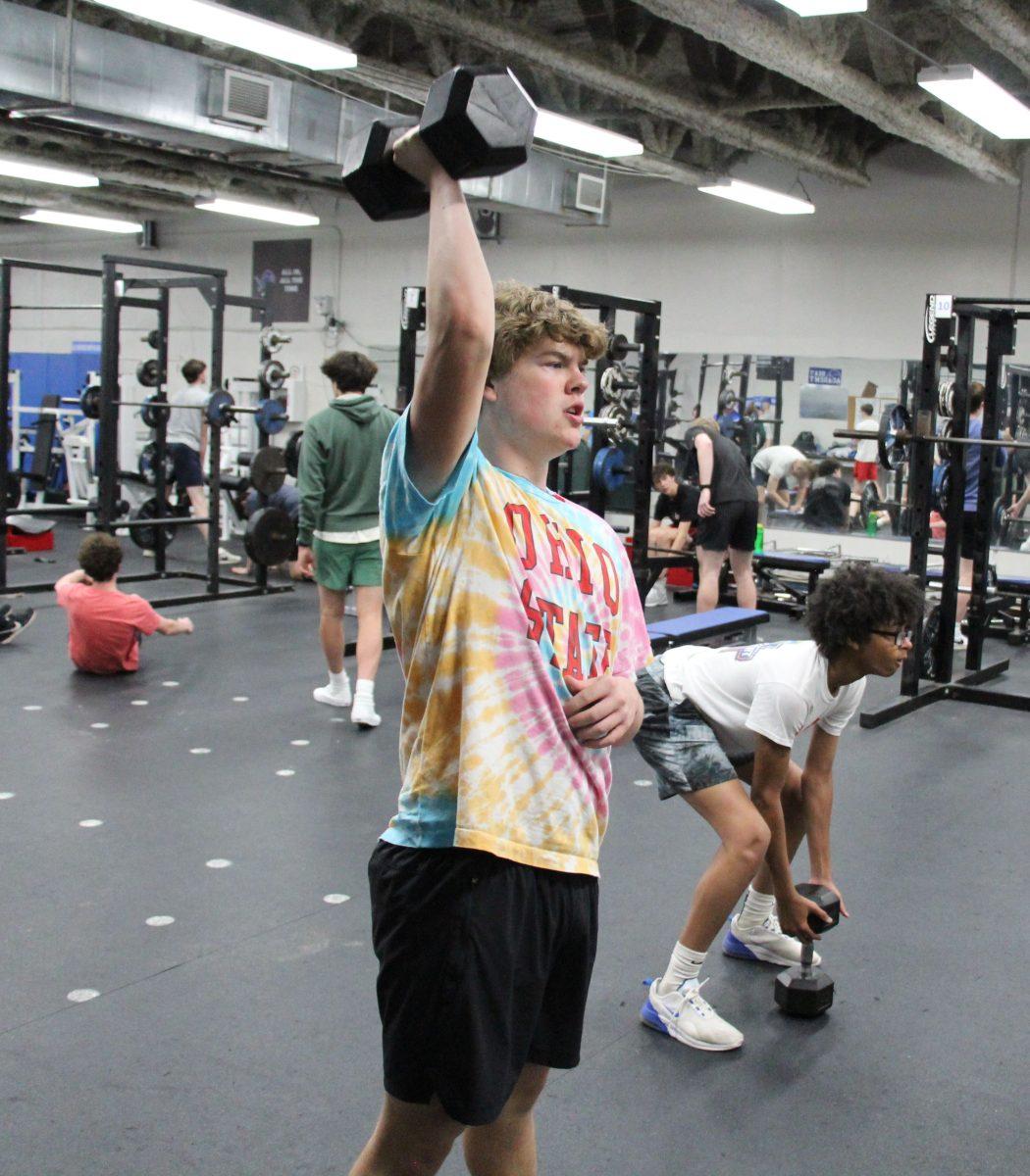 Senior Tommy Webster does a dumbbell push press in the weight room with the lacrosse team.
(Photo by Bennett Bloebaum)