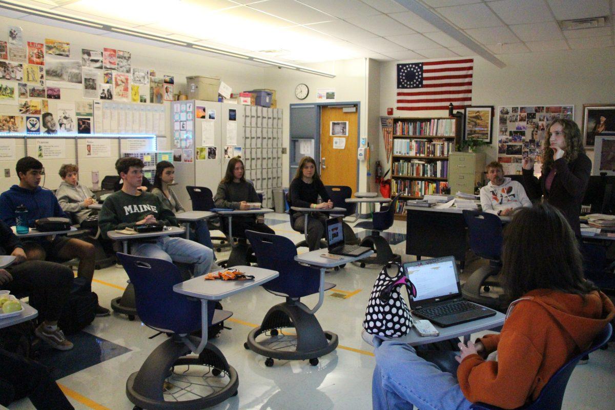 Co-president and senior Addison Helon discusses a canned food drive with BRISC members in social studies teacher Scott King-Owen's room. (Photo by Alex Flamm)