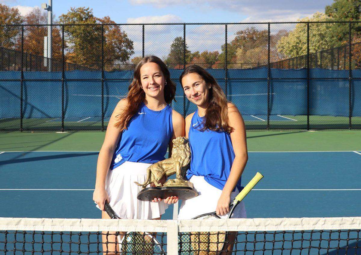 Senior co-captains Olivia Ramsden and Remy Schottenstein hold Leo the Lion on the tennis court for good luck. (Photo by Livi Tuber)