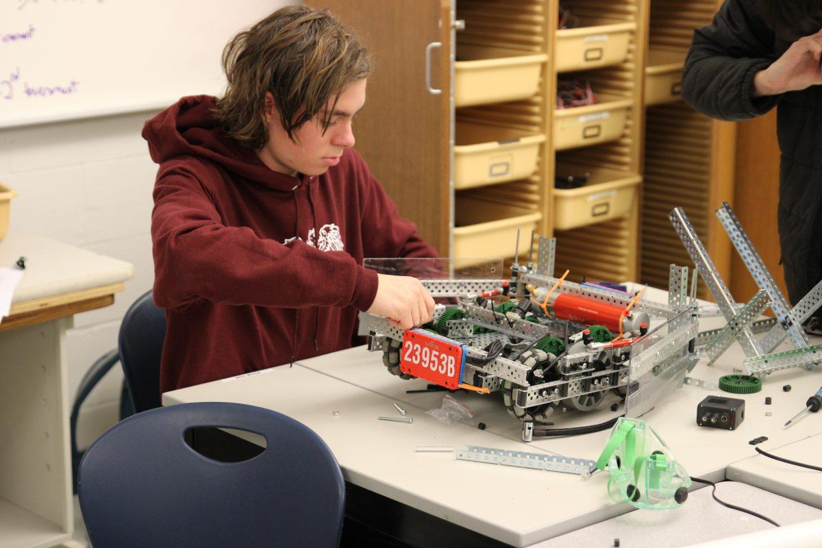 Junior Holden Gohs tinkers with the team robot during a Robotics meeting Tuesday, Jan. 30. (Photo by Henry Elmore)