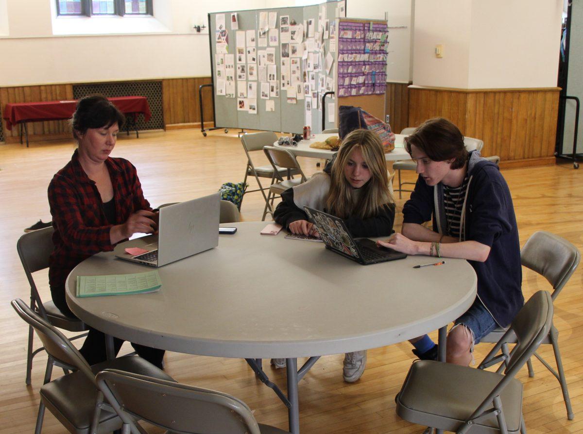 Mosaic adviser Maggie Biroschak works with sophomore Mya Paulsen and junior Henry Pattinson on their Capstone projects. (Photo by Owen Parsons)