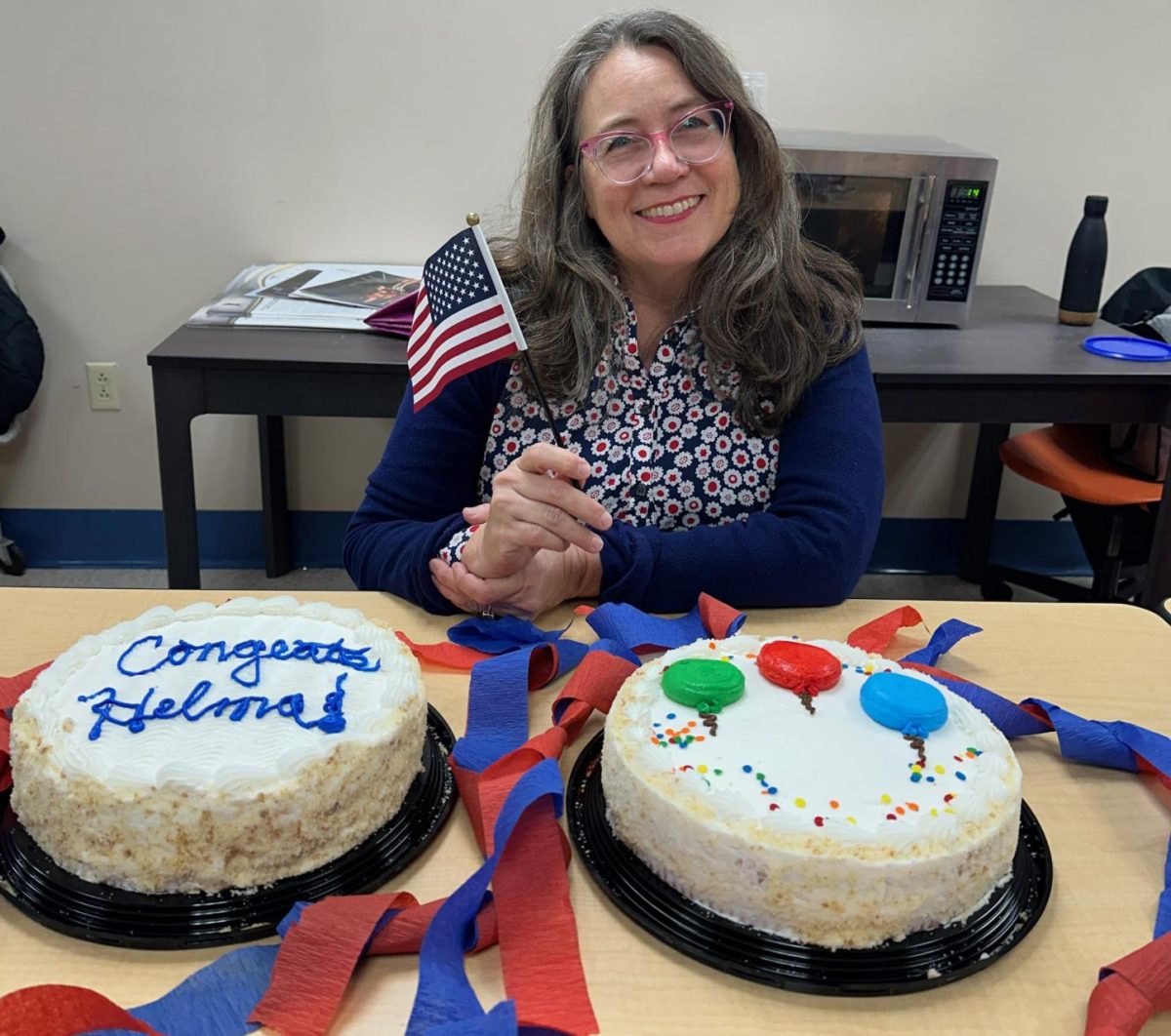 Art teacher Helma Groot smiles with her cake at the
high school staff’s citizenship celebration.