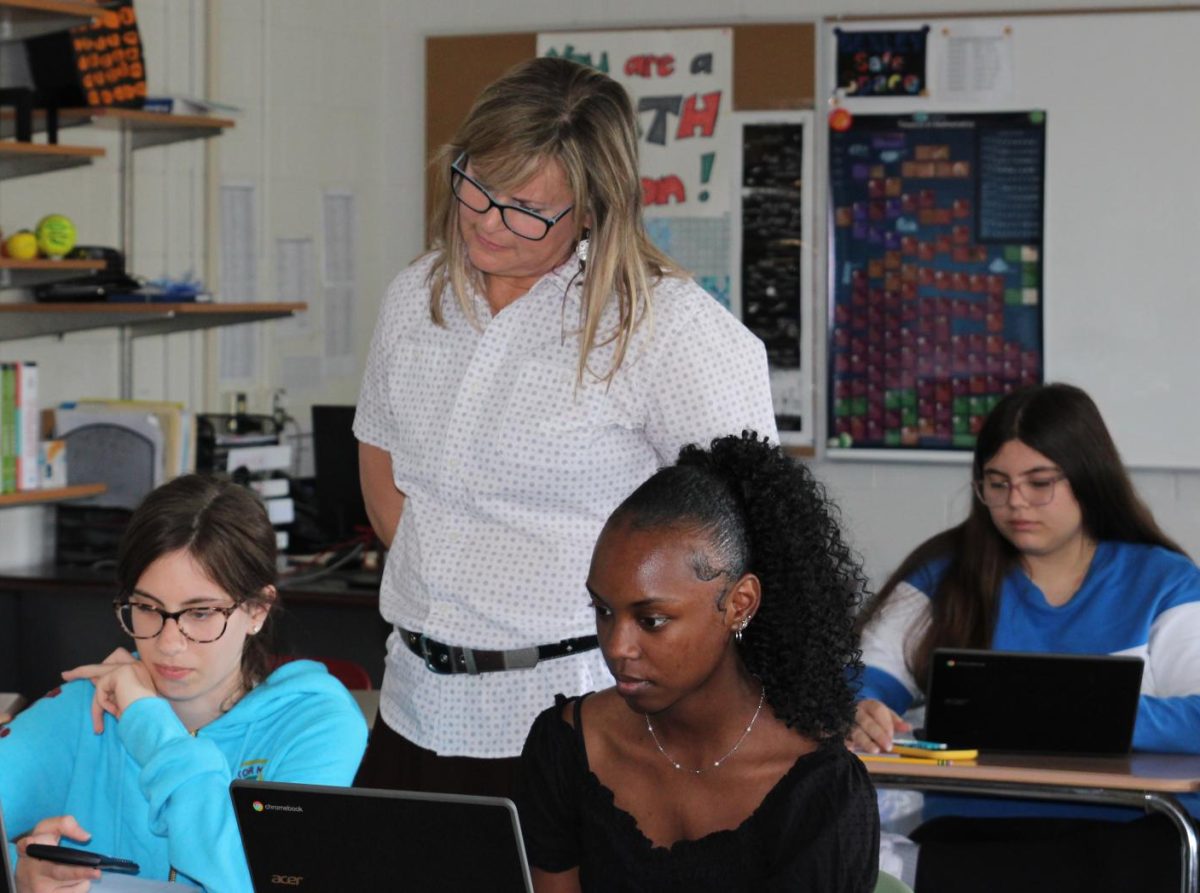 New math teacher Jennifer Kirk checks in on students during class.