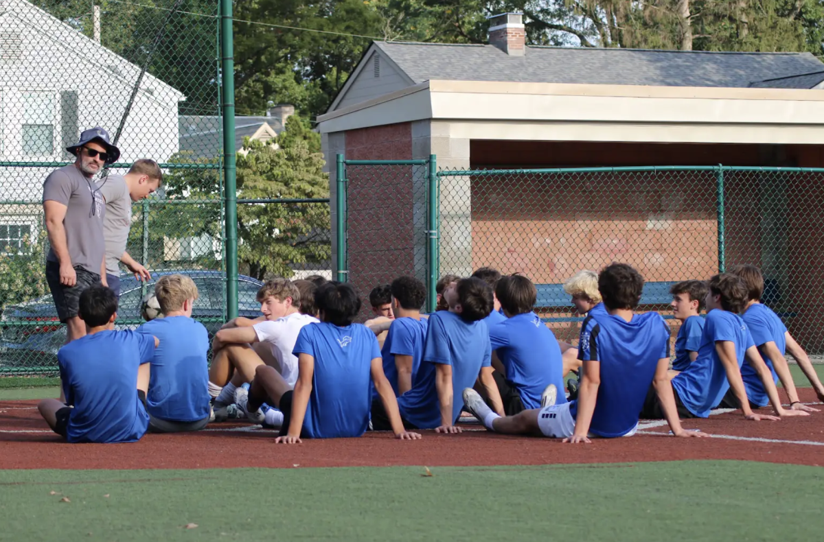 Members of the boys soccer team listen to directions from their coach on the Cassingham field. 
