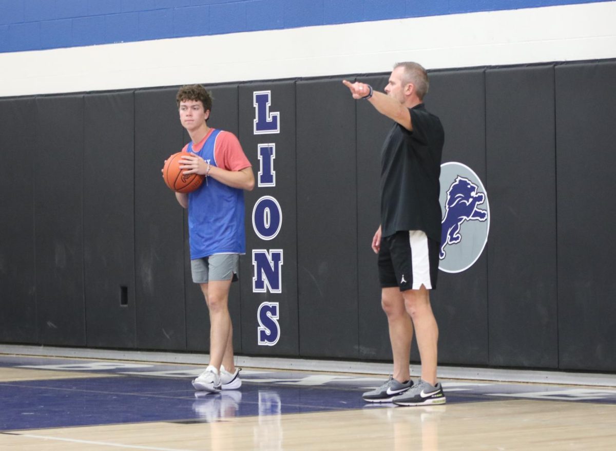 Head Coach David Leland directs senior Kyle Hagely to run a play during an open gym.