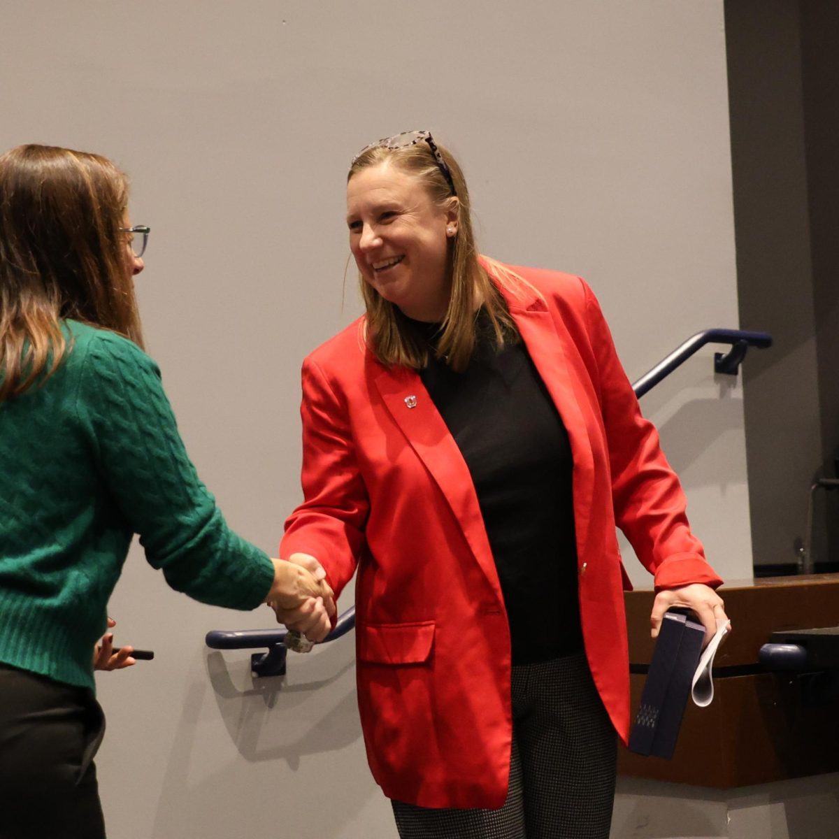 Distinguished Alumni Award honoree Kacy King shakes the hand of Bexley Education Foundation Director of Alumni & Donor Relations Wendy Hauswirth after speaking at the Distinguished Alumni assembly Monday, Nov. 24. King was honored for her work as the Senior Associate Athletic Director and Executive Director of the Student-Athlete Support Services Office at The Ohio State University.