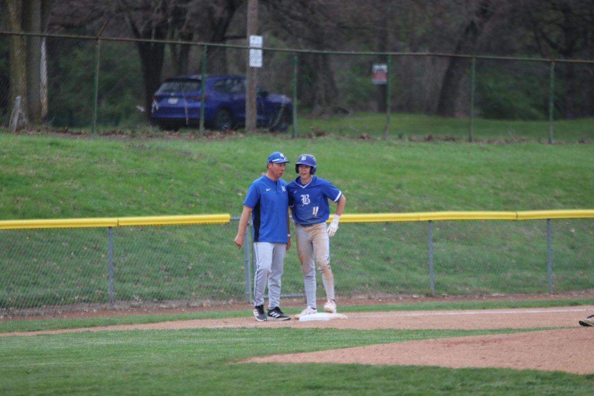 Head coach Brett Counts instructs
senior Kyle Hagely on third base
March 31.