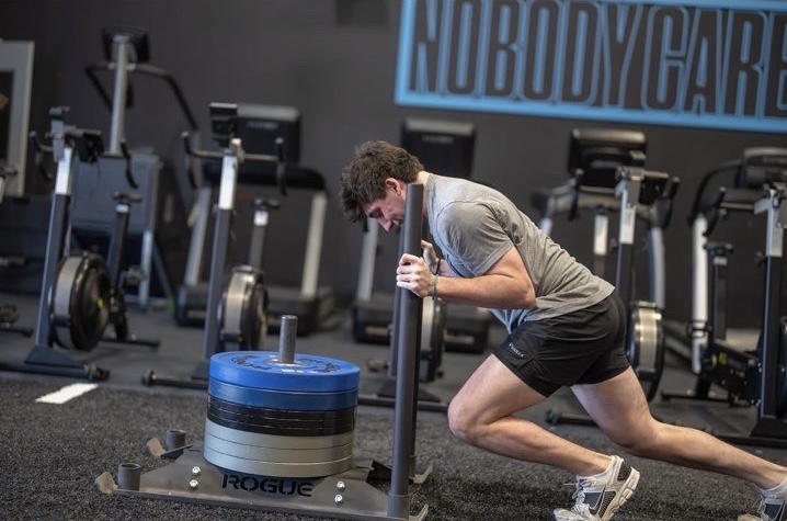 Senior Kaleb Krasnow does a sled push during his strength training session at CrossFit Bexley March 24.