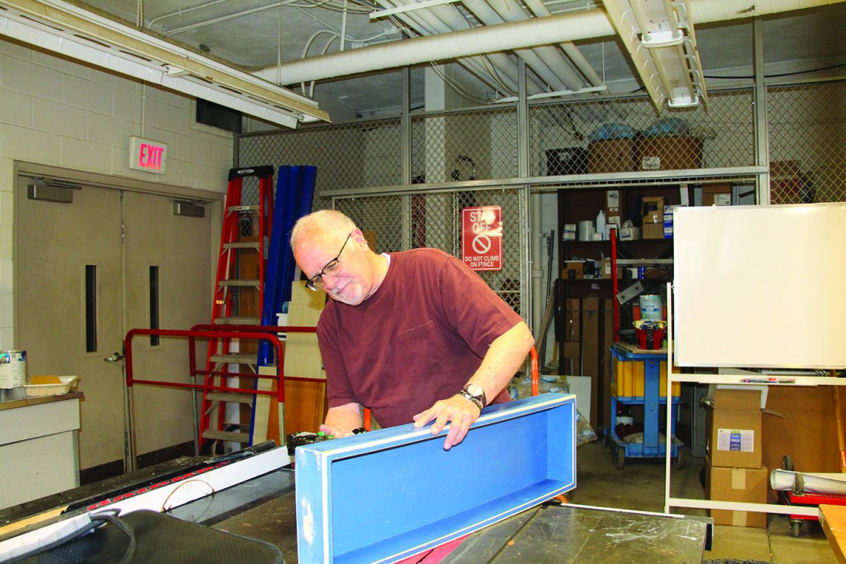 Maintenance staff member Mark Cooper nails together a box.