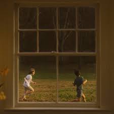 Two boys run through the yard on Noah Kahan’s album cover for “The Great Divide.” (Fair use Mercury Records)